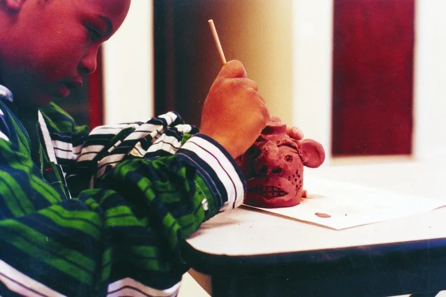 Large-scale metal ant sculpture installation against winter tree branches