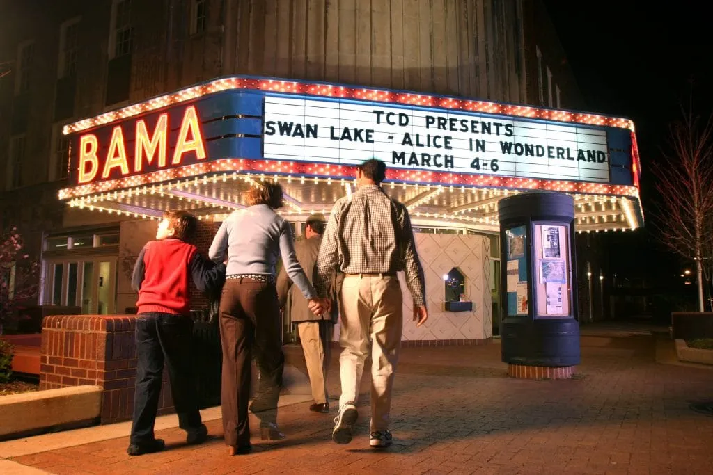 BAMA Theatre entrance at night featuring Swan Lake and Alice in Wonderland productions